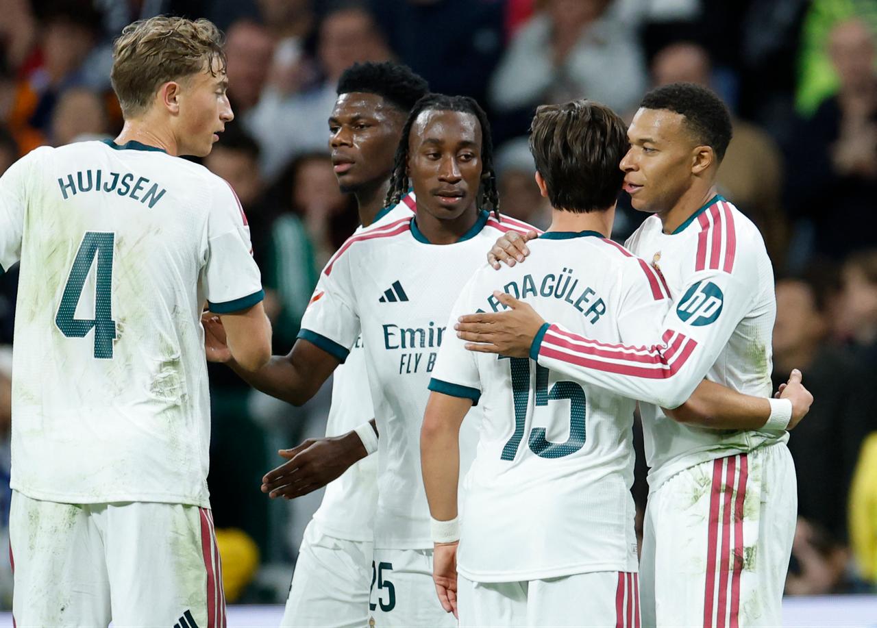 Real Madrid's French forward #10 Kylian Mbappe (R) celebrates with Real Madrid's Turkish midfielder #15 Arda Guler scoring his team's second goal with teammates during the Spanish league football match between Real Madrid CF and Sevilla FC at the Santiago Bernabeu stadium in Madrid on October 18, 2026. (AFP Photo)