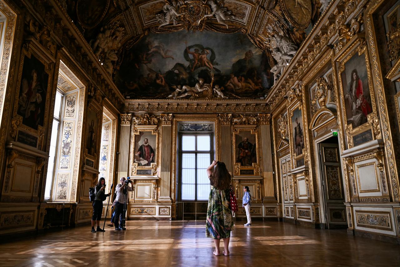 Visitors view paintings and ornate decorations inside a gallery at the Louvre Museum in Paris, France, Oct. 13, 2026. (AFP Photo)
