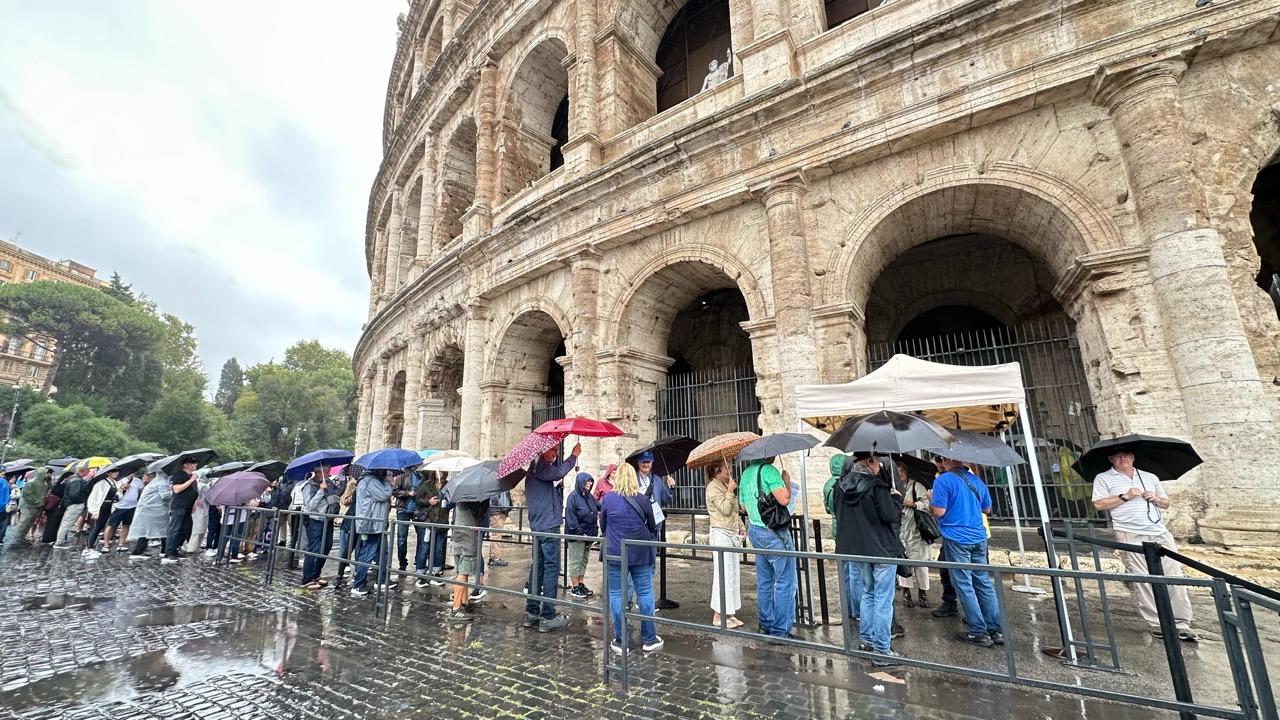 Visitors holding umbrellas wait in line outside the Colosseum amid rainy weather in Rome, Italy, on October 19, 2026. (AA Photo)