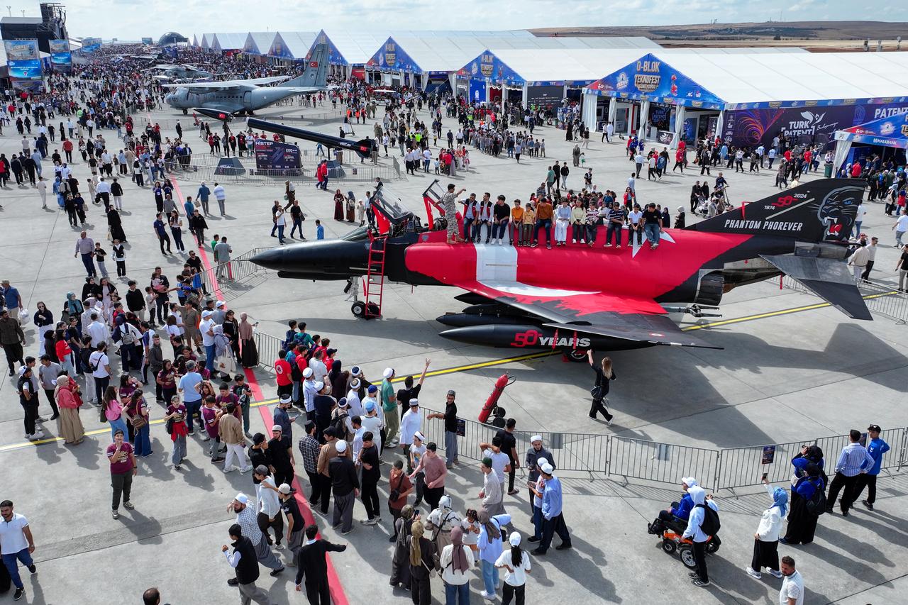 People walk through stalls during the second day of the TEKNOFEST aviation, space, and technology festival at Sanliurfa GAP Airport in Sanliurfa, Türkiye, on October 1, 2026. (AA Photo)