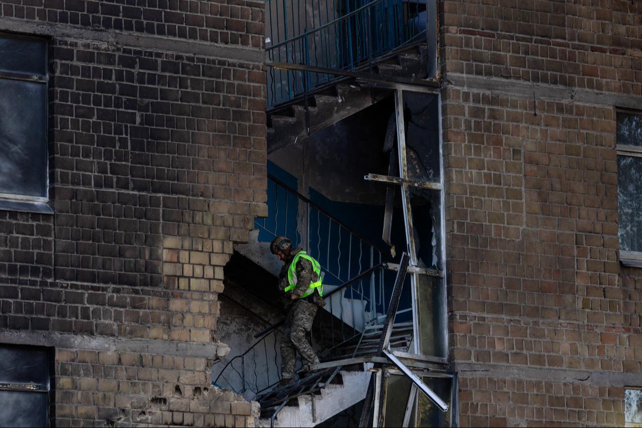A police officer walks down the stairs searching for drone components that did not explode at a damaged school following a drone strike in Kyiv on October 1, 2026. (AFP Photo)