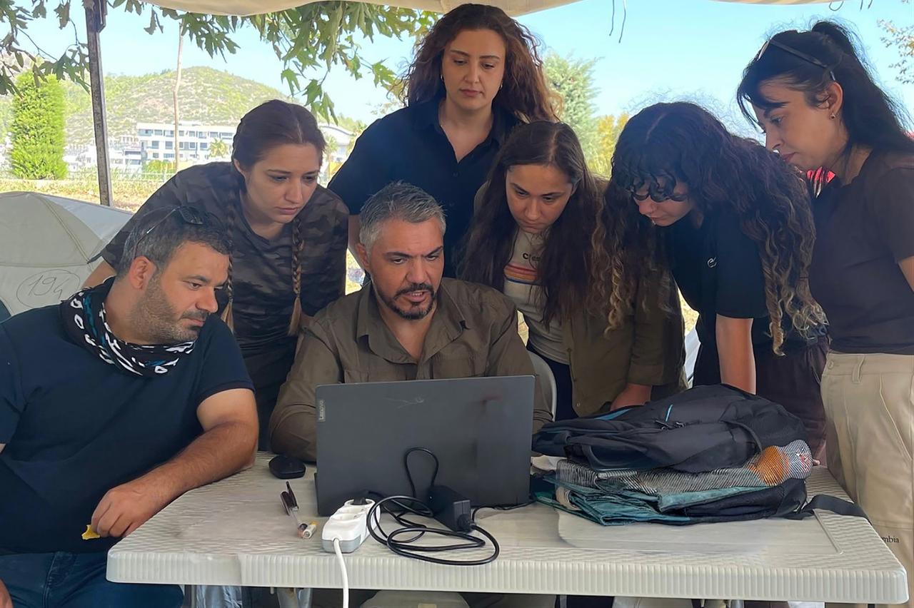 Assoc. Prof. Tuna Akcay, center, reviews field data with members of the archaeological survey team at Selinus Ancient City in Gazipasa, Antalya, Türkiye. (Photo via Selinus Survey Project)