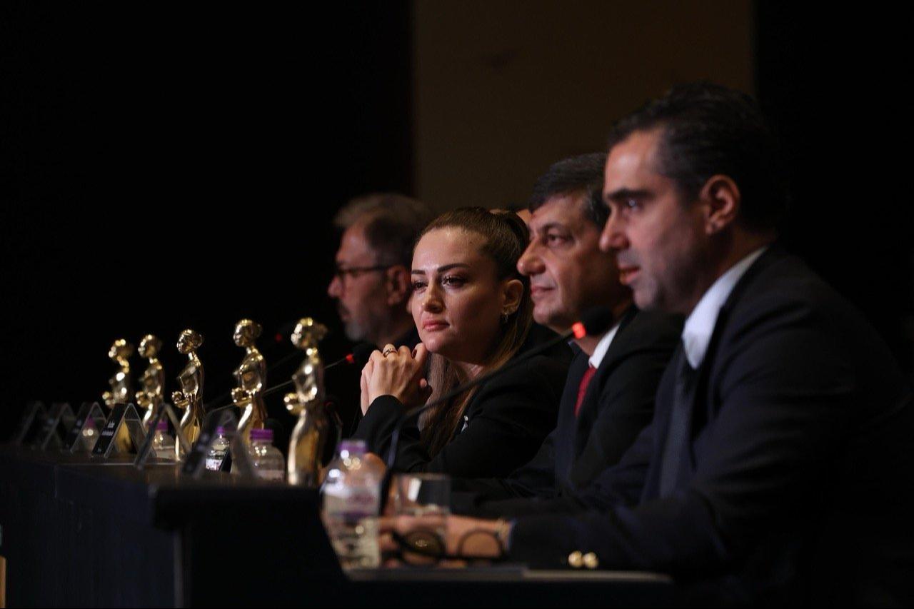Members of a film festival committee attend a press conference with Golden Orange statuettes displayed on the table in Antalya, Türkiye. (Photo via Antalya Golden Orange Film Festival)