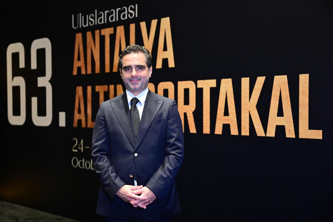 Deniz Yavuz, one of the festival representatives, poses in front of a promotional backdrop for the 63rd International Antalya Golden Orange Film Festival in Antalya, Türkiye, Oct. 19, 2026. (AA Photo)