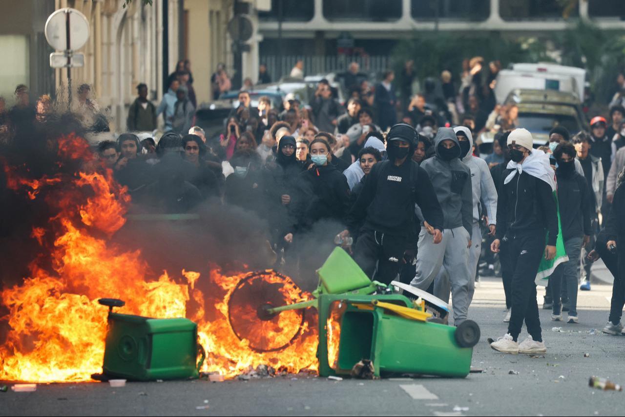 A student puts trashes into a fire as protesting students carry out blockading action near place de la Nation, in Paris, on October 2, 2026. (AFP Photo)