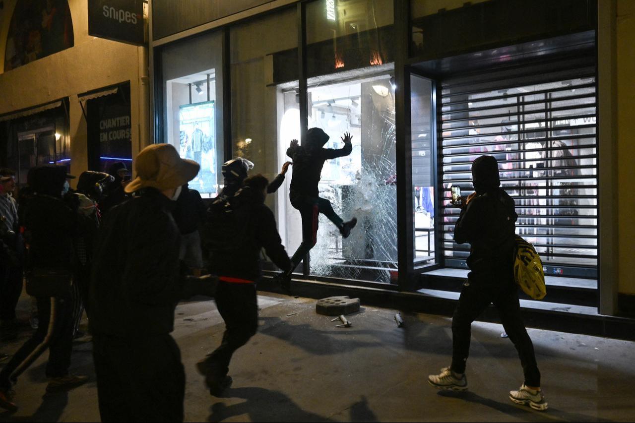 People try to destroy the window of a Snipes store near Châtelet - Les Halles as clashes erupted at Place de la République following demonstrations in central Paris, on Oct. 18, 2026. (AFP Photo)