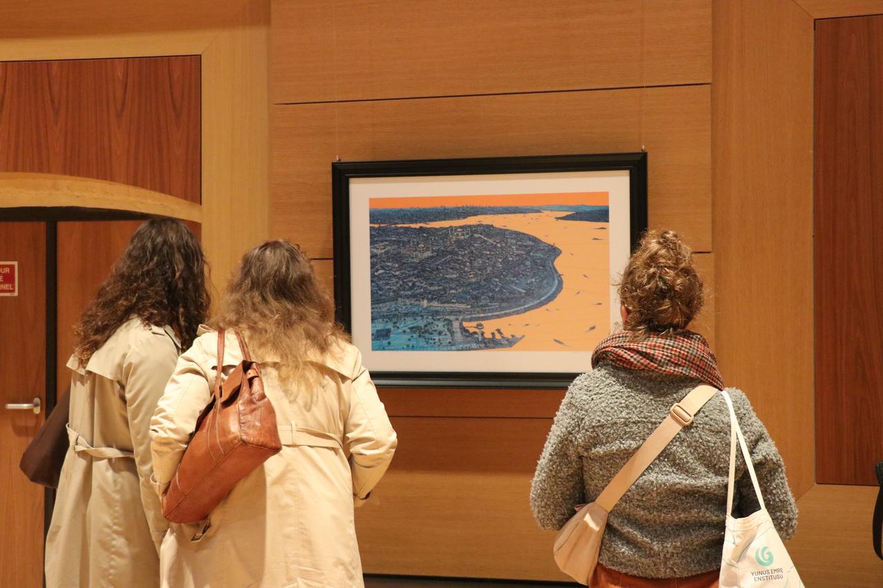 Three visitors examine an artwork depicting Istanbul and the Bosphorus at the "Istanbul: One City, A Thousand Perspectives" exhibition in Paris, France, Oct. 19, 2026. (AA Photo)