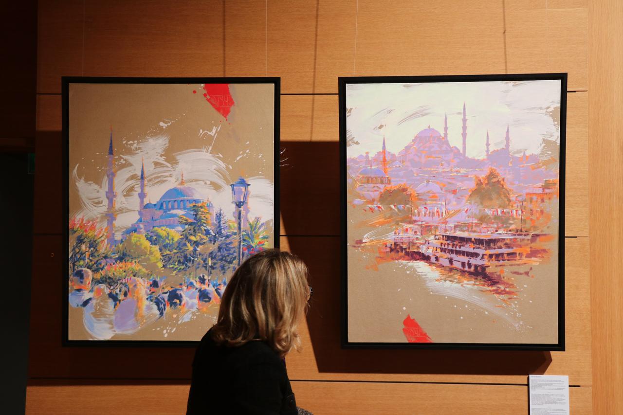 A visitor views paintings depicting Istanbul's historic mosques and waterfront at the "Istanbul: One City, A Thousand Perspectives" exhibition in Paris, France, Oct. 19, 2026. (AA Photo)