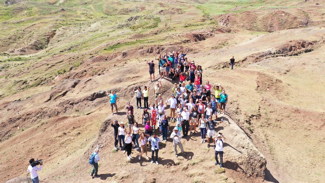 The image shows a tour group gathered at the boat-shaped Durupinar formation. (Photo via Noah's Ark Scans)