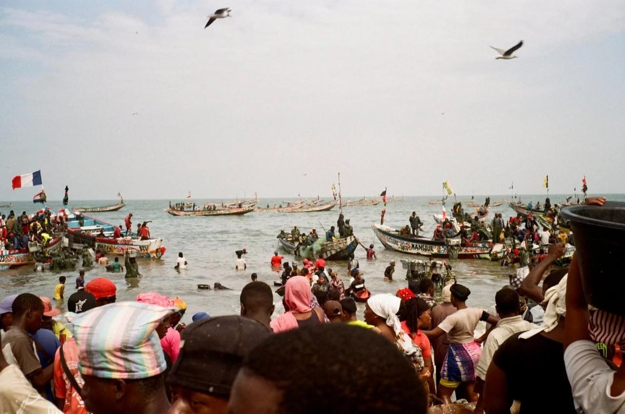 Artisanal fishers offload their catches to waiting men at one of the largest fish landing sites in the Gambian fishing village of Tanji. (Photo via Regina Lam)