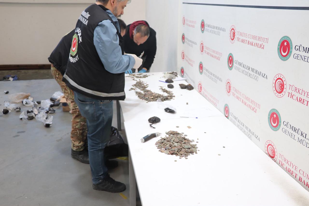 Turkish customs officers examine historical coins and other artifacts seized during anti-smuggling operations at the Ipsala and Kapikule border crossings in Edirne, Türkiye. (Photo via Ministry of Culture and Tourism)