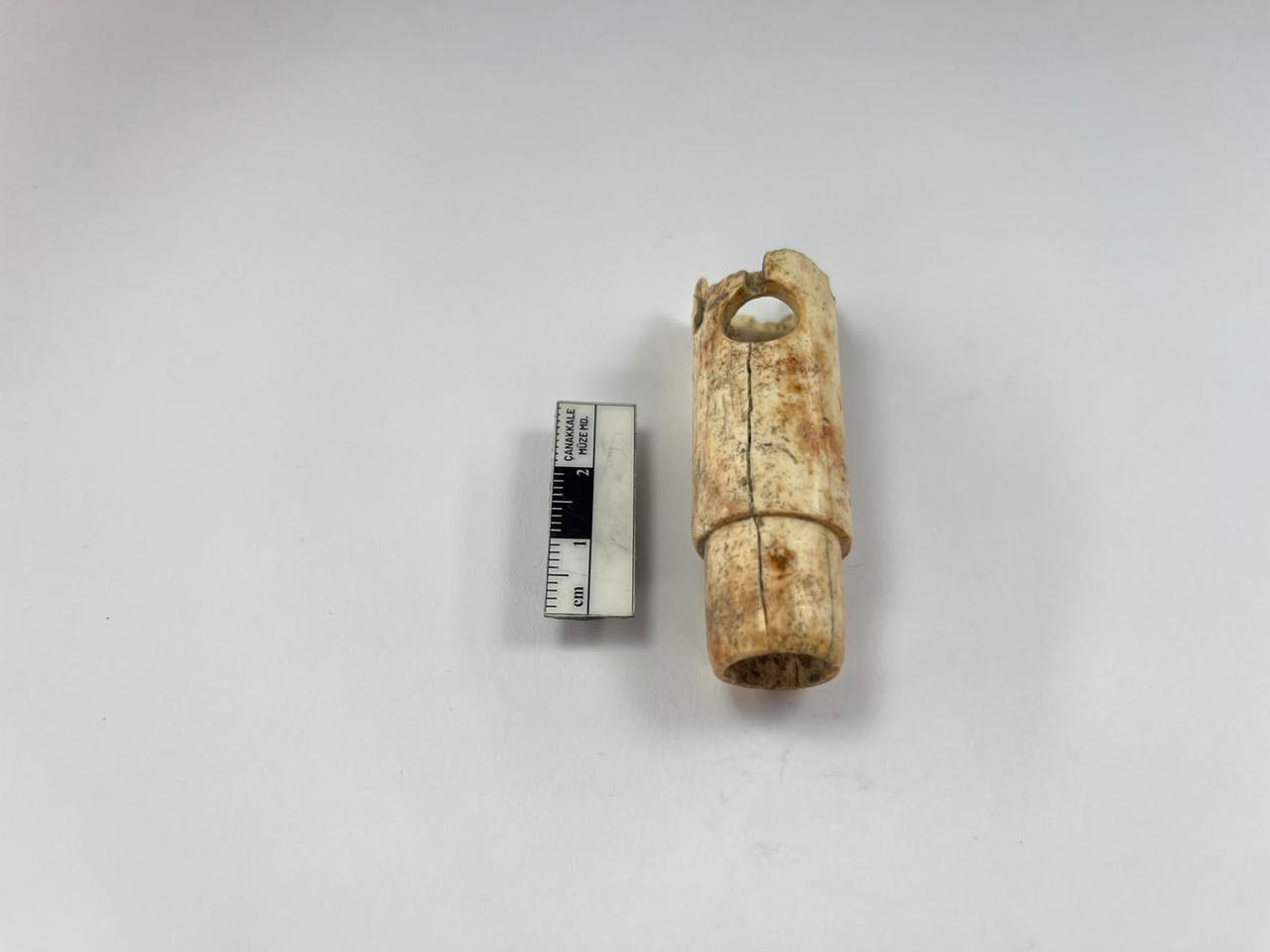 A 2,800-year-old bone flute unearthed at the ancient city of Troy in Türkiye is displayed alongside a measuring scale. (Photo via Türkiye's Ministry of Culture and Tourism)