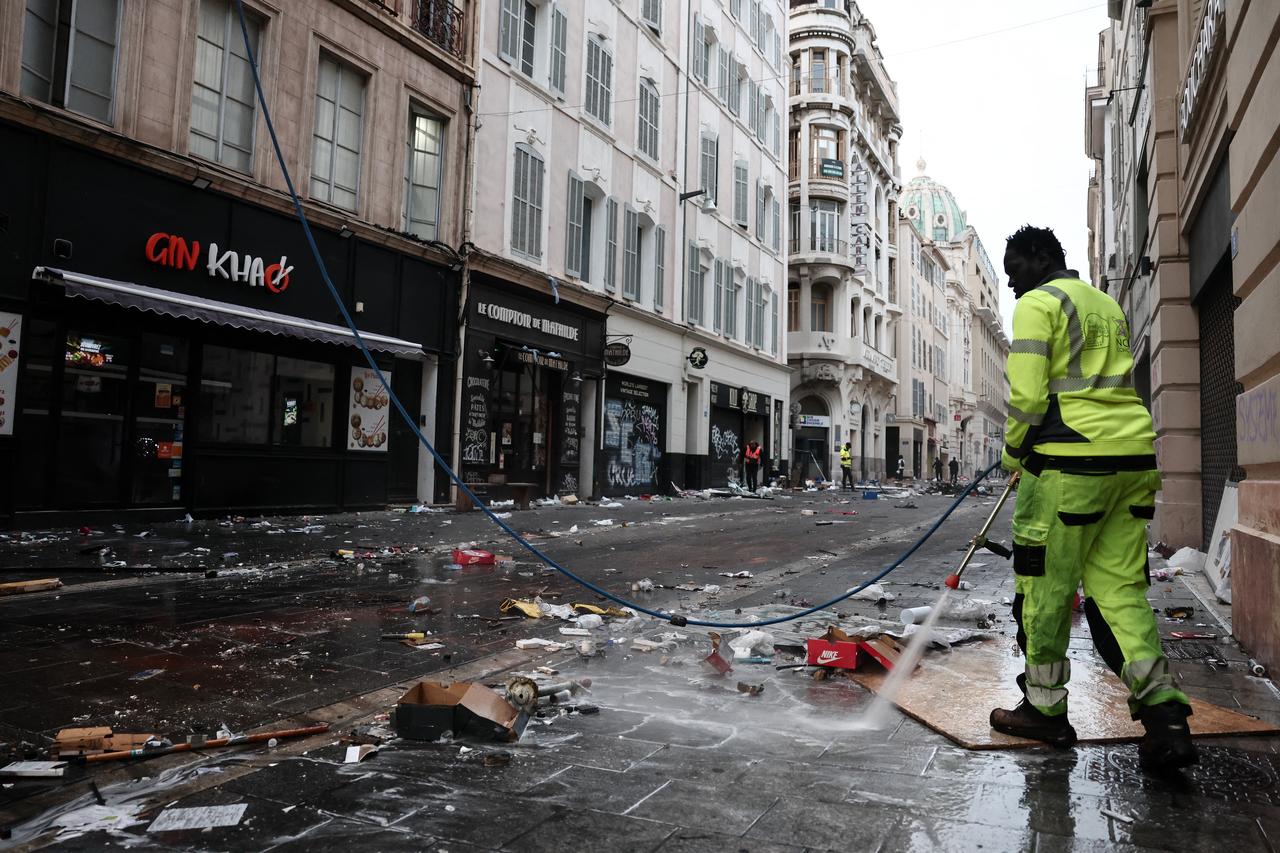 A municipal cleaning worker cleans a street a day after nationwide protests against the "high cost of living", in Marseille on Oct. 18, 2026. (AFP Photo)