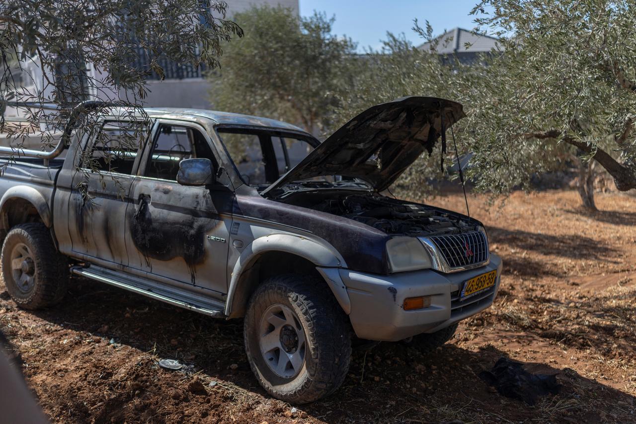 The carcass of a burnt vehicle stands in a Palestinian-owned olive grove following a reported attack by Israeli settlers, in the Israeli-occupied West Bank village of Turmus Ayya on October 19, 2026. (AFP Photo)