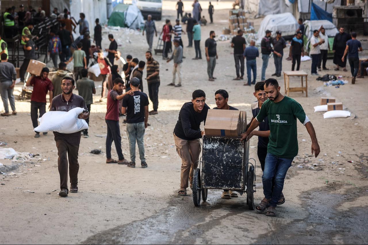 Men transport relief packages at a World Food Program distribution centre in Gaza City on October 22, 2026. (AFP Photo)
