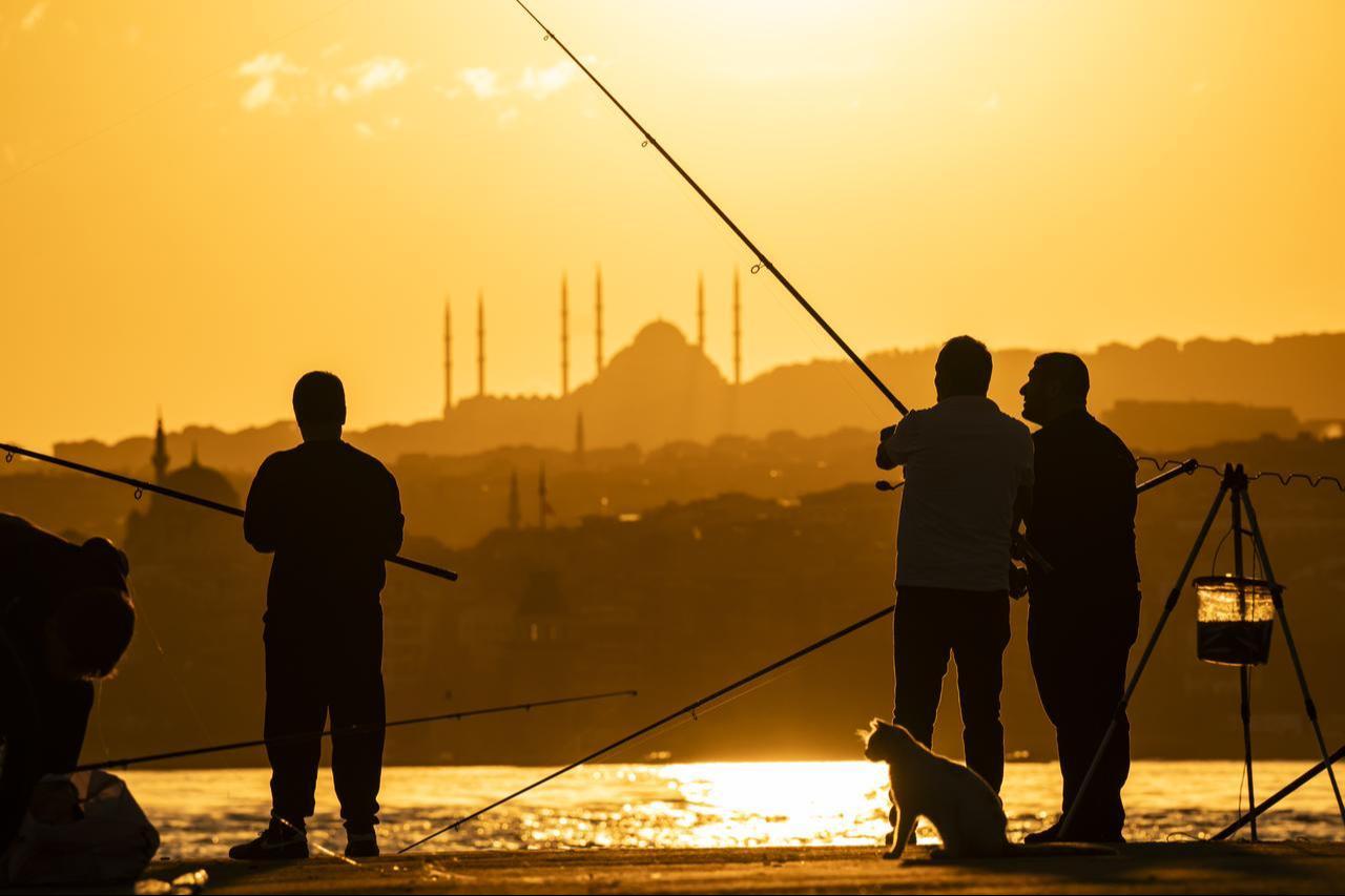 Silhouettes of amateur anglers fishing with rods at sunrise are seen along the coastline of Sarayburnu in Istanbul, Türkiye, on August 16, 2026. (AA Photo)
