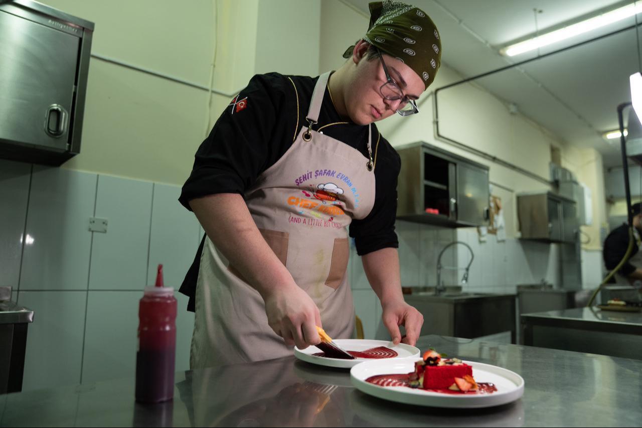 While working in a professional training kitchen in Istanbul, Türkiye, on Jan. 12, 2026, a vocational high school student plates a dessert as part of hands-on gastronomy education at Beylikduzu Sehit Safak Evran Vocational and Technical Anatolian High School. (AA Photo)