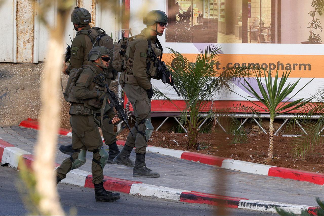 Israeli army soldiers walk towards the bodies of two armed Palestinian men after a fire exchange at the northern checkpoint of Hebron in the Israeli-occupied West Bank on October 23, 2026. (AFP Photo)