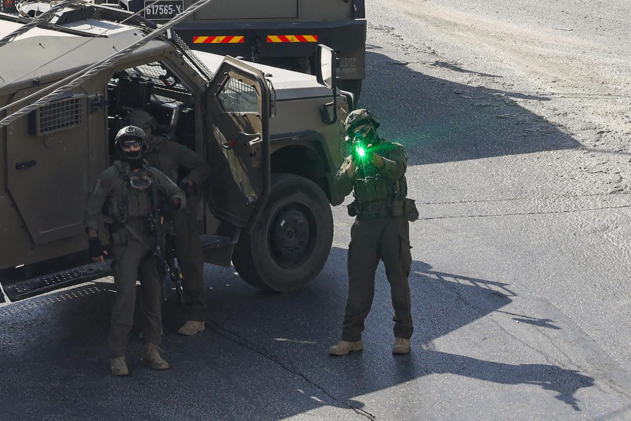 An Israeli soldier aims is weapon as Israeli security forces patrol the area where the houses of the two Palestinian gunmen, who killed two Israeli soldiers and injured three others earlier in the day, are located, in the Israeli-occupied West Bank city of Hebron on October 23, 2026. (AFP Photo)