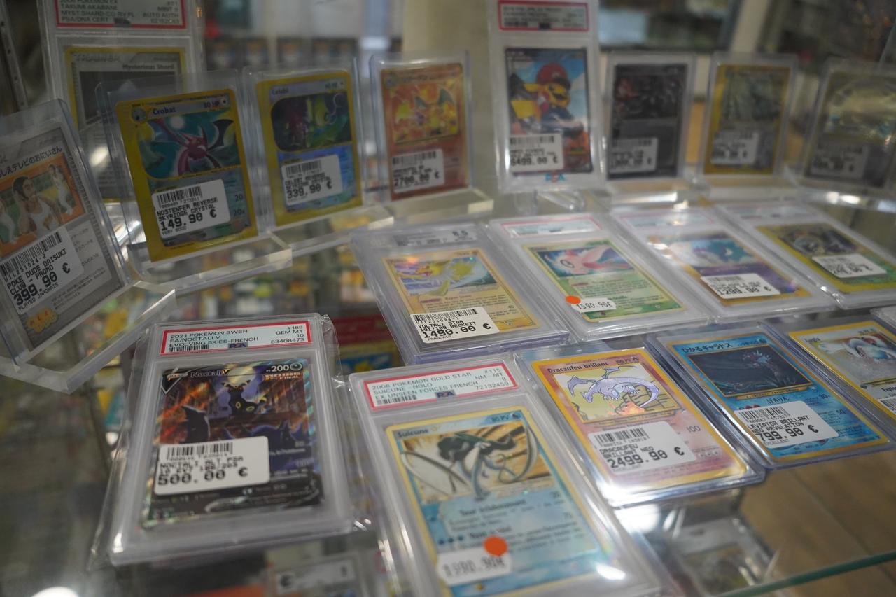 Rare and collectible Pokemon trading cards, including professionally graded cards, are displayed with price tags at a retail store. (Adobe Stock Photo)