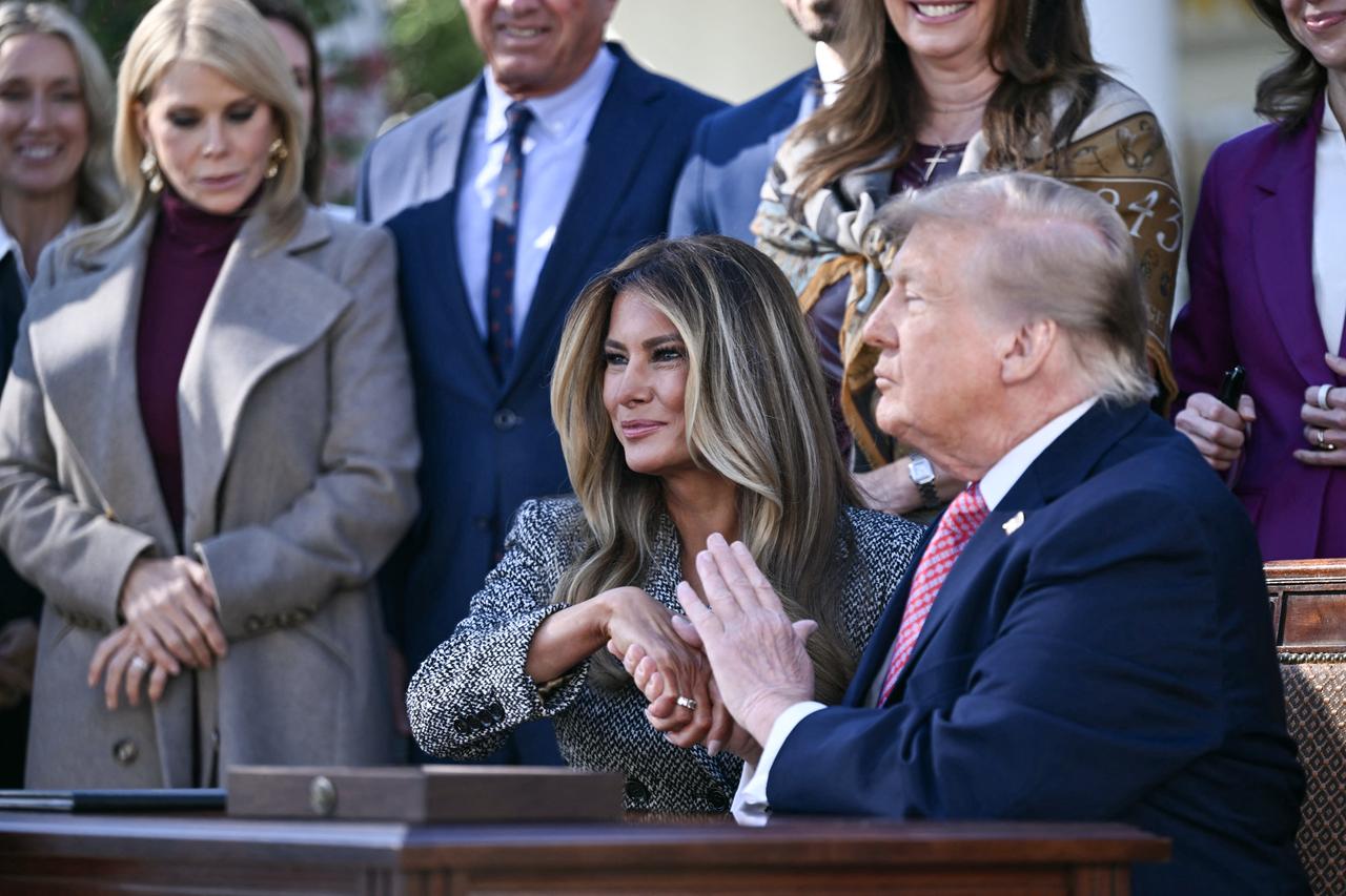 US President Donald Trump and US First Lady Melania Trump shake hands after signing an executive order during a ceremony in the Rose Garden of the White House in Washington, on Oct. 19, 2026. (AFP Photo)