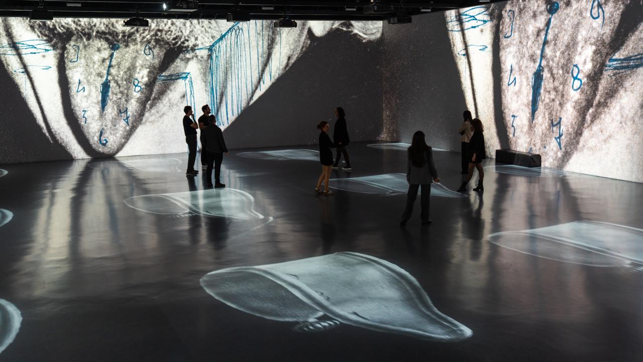 Visitors walk through an immersive installation displaying surrealist imagery inspired by Salvador Dali's works at a digital art exhibition in Istanbul, Türkiye, Oct. 22, 2026. (AA Photo)