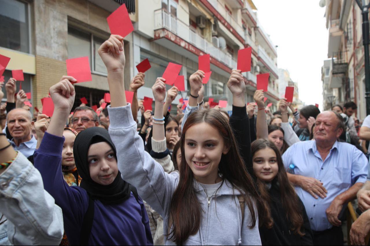 Turks from Western Thrace hold red cards and banners in Xanthi, Greece, on September 25, 2023. (AA Photo)