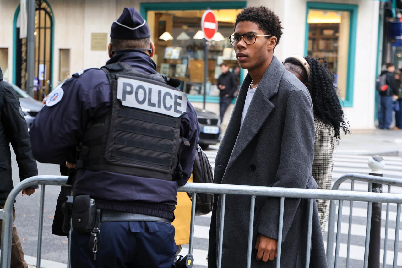 President of the administrative council of student association Renouveau Lyceen Nathanael Combary walks past a police officer as he arrives for a meeting with France's President for the first time since the student unrest began, at the Elysee Presidential Palace in Paris on October 23, 2026. (AFP Photo)