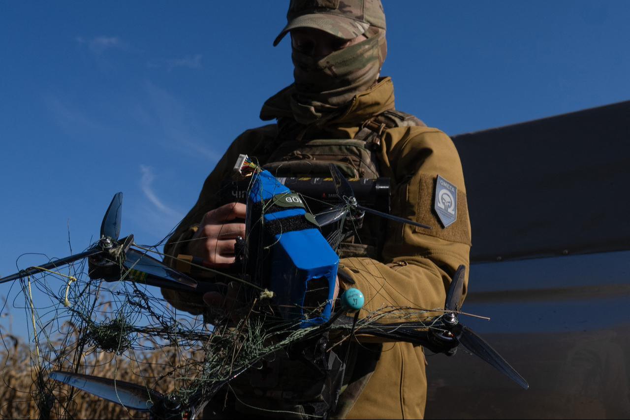 A Ukrainian serviceman holds an FPV drone that was intercepted using the Ukrainian-made Chipa net launcher during a training exercise at an undisclosed location on October 20, 2026. (AFP Photo)
