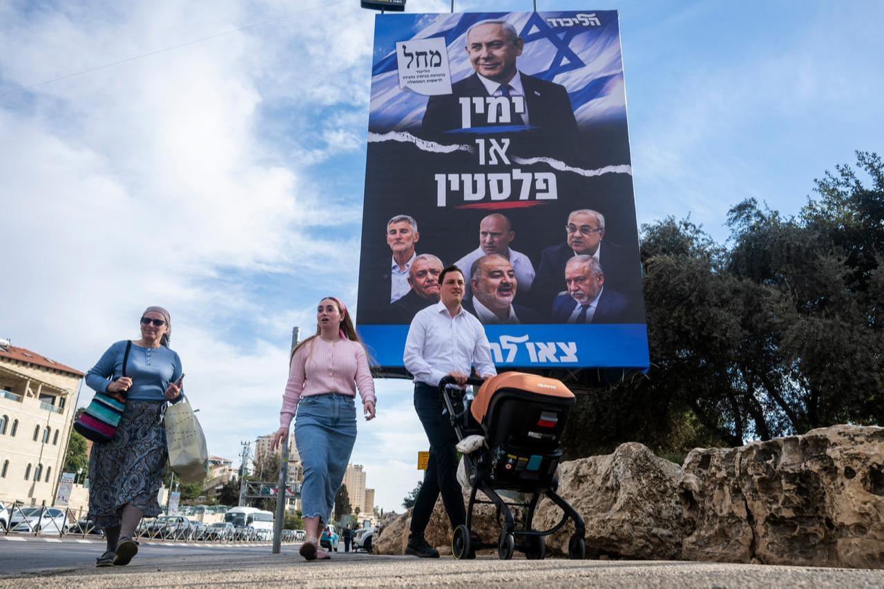 People walk past an electoral campaign billboard for Israeli Prime Minister Benjamin Netanyahu's Likud party in Jerusalem on Oct. 20, 2026. (AFP Photo)