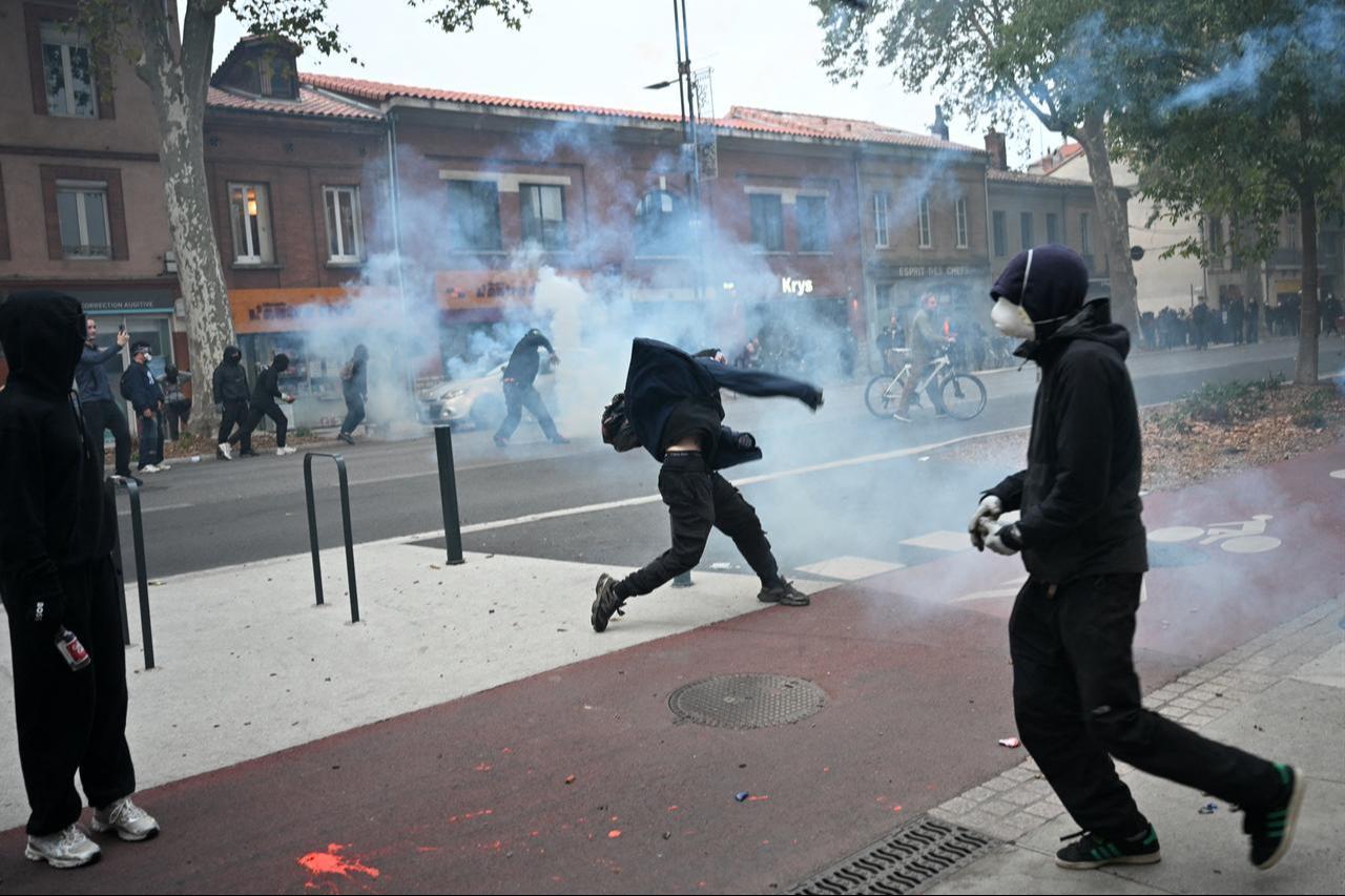 A protester throws a projectile towards police forces as clashes erupted on the sidelines of a demonstration in favor of purchasing power, the protection of public services, and fiscal and social justice, in Toulouse, southwestern France on Oct. 24, 2026. (AFP Photo)