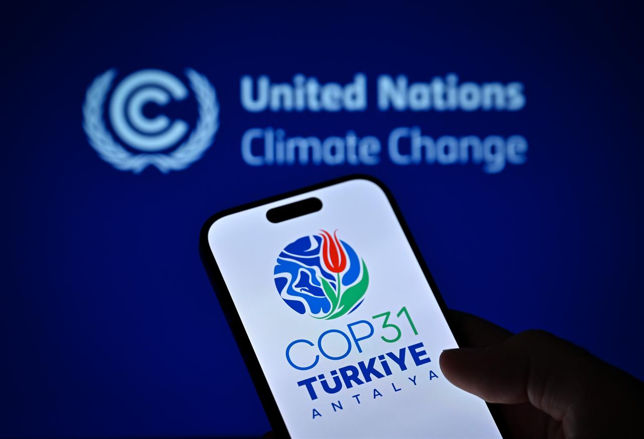 The COP31 Türkiye Antalya logo appears on a smartphone screen against the United Nations Climate Change emblem, Oct. 23, 2026. (AA Photo)