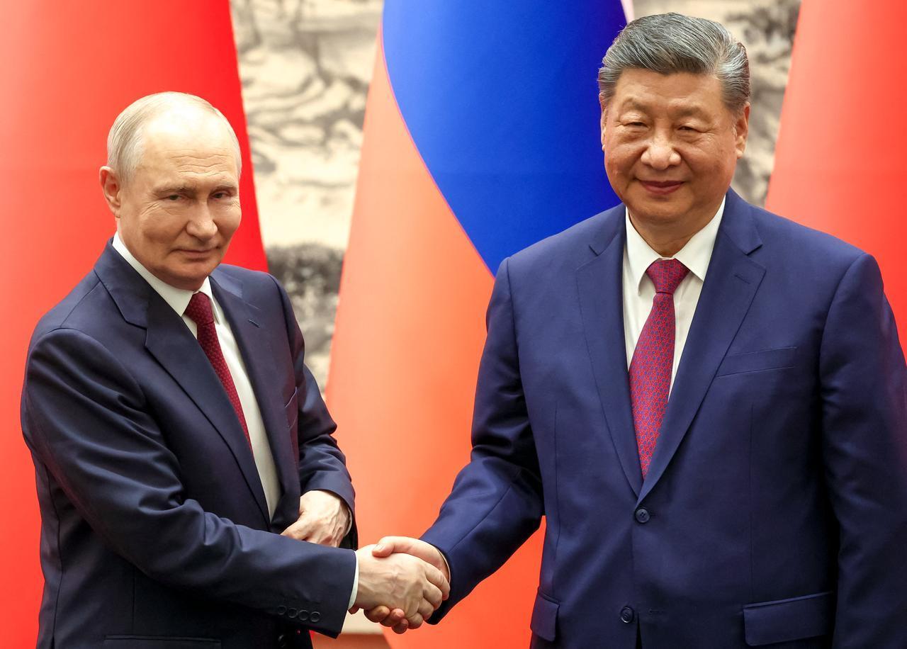 Russia's President Vladimir Putin and China's President Xi Jinping shake hands during a signing ceremony following their talks in Beijing on May 20, 2026. (AFP Photo)