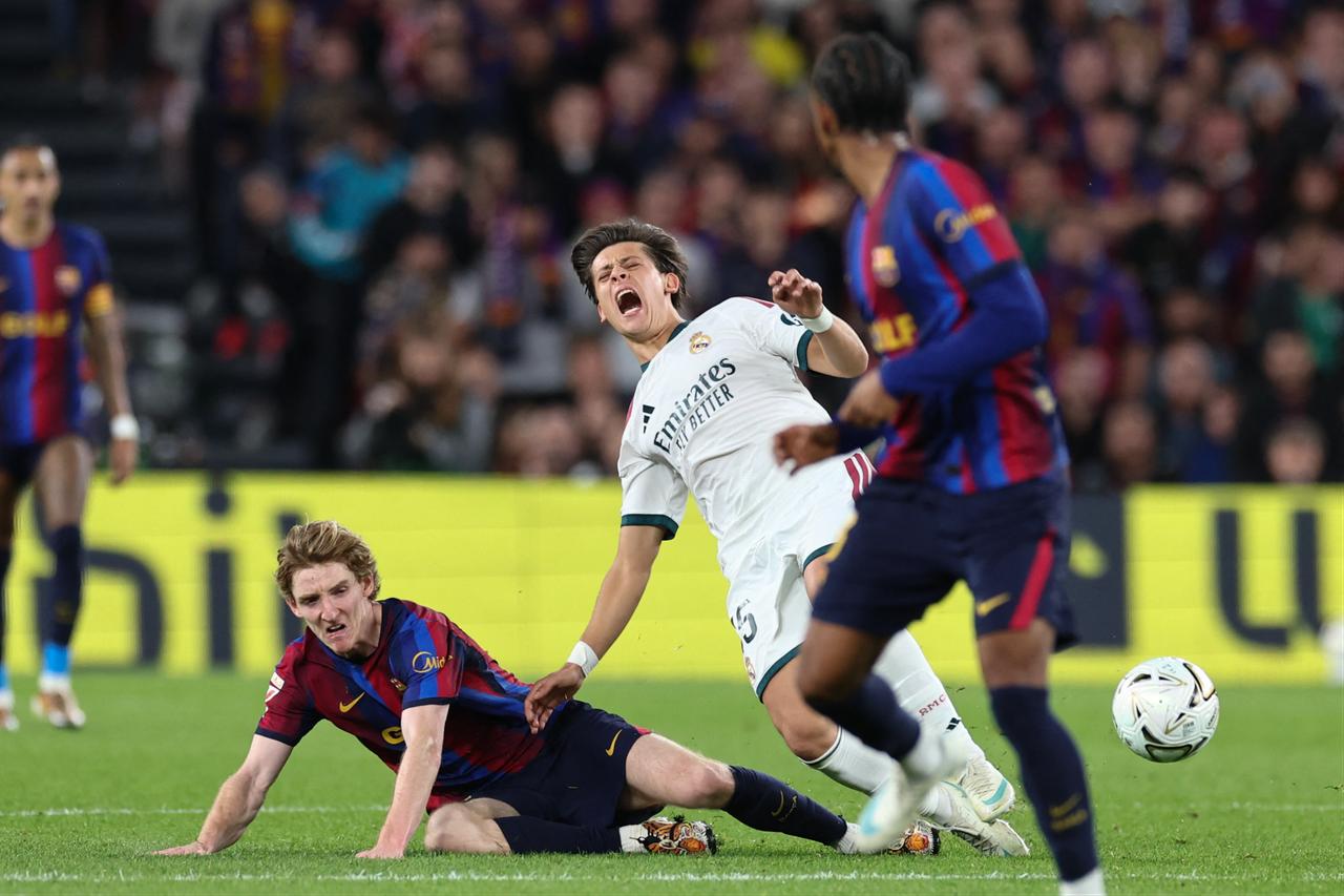 Barcelona's English forward #17 Anthony Gordon (L) fouls Real Madrid's Turkish midfielder #15 Arda Guler during the Spanish league football match between FC Barcelona and Real Madrid CF at Camp Nou Stadium in Barcelona on October 25, 2026. (AFP Photo)