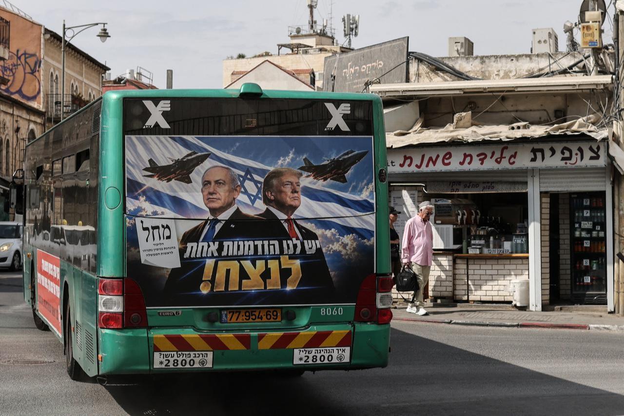 A bus bearing a campaign poster featuring Israeli Prime Minister and Likud party chairman Benjamin Netanyahu alongside US President Donald Trump drives through Jerusalem on Oct. 26, 2026, on the eve of Israel's legislative elections. (AFP Photo)