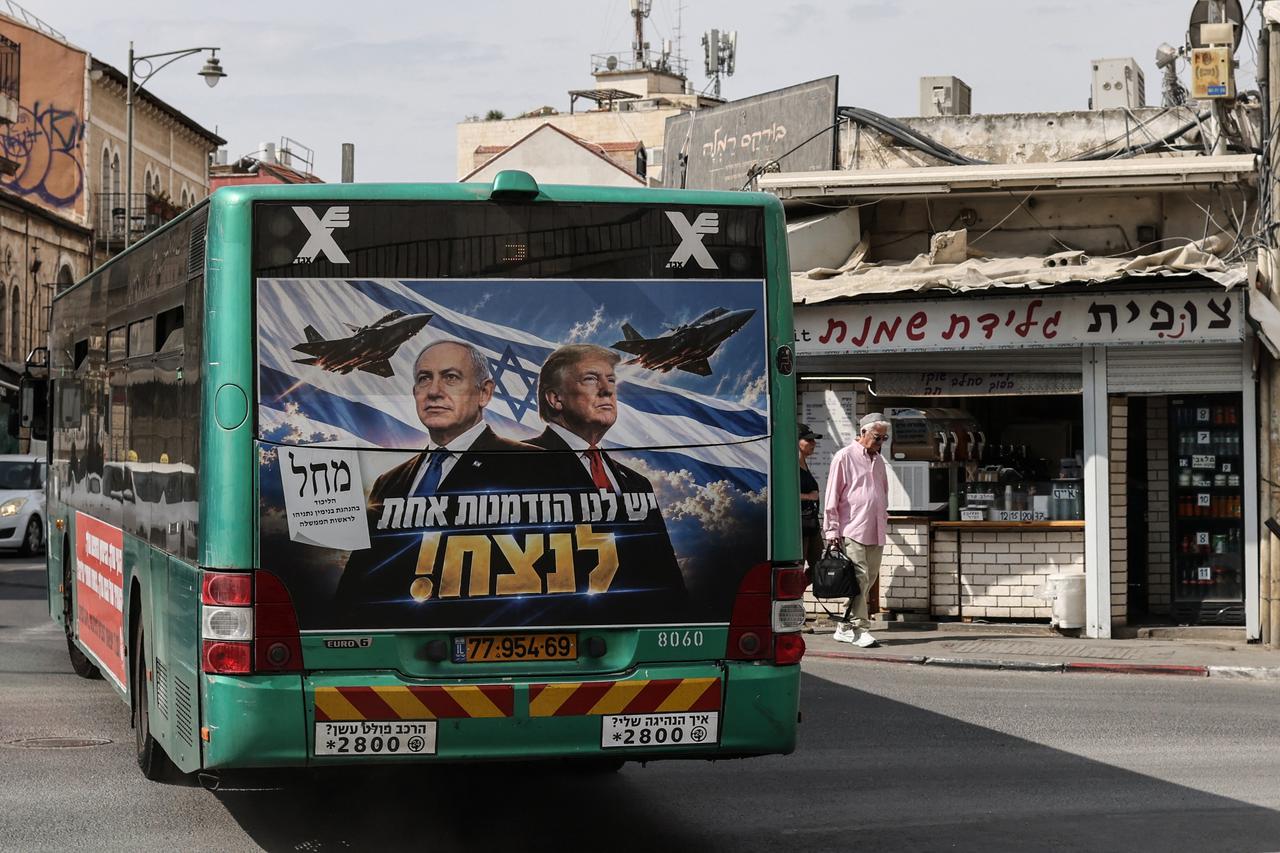 A bus bearing a campaign poster featuring Israeli Prime Minister Benjamin Netanyahu alongside US President Donald Trump drives through Jerusalem on October 26, 2026. (AFP photo)