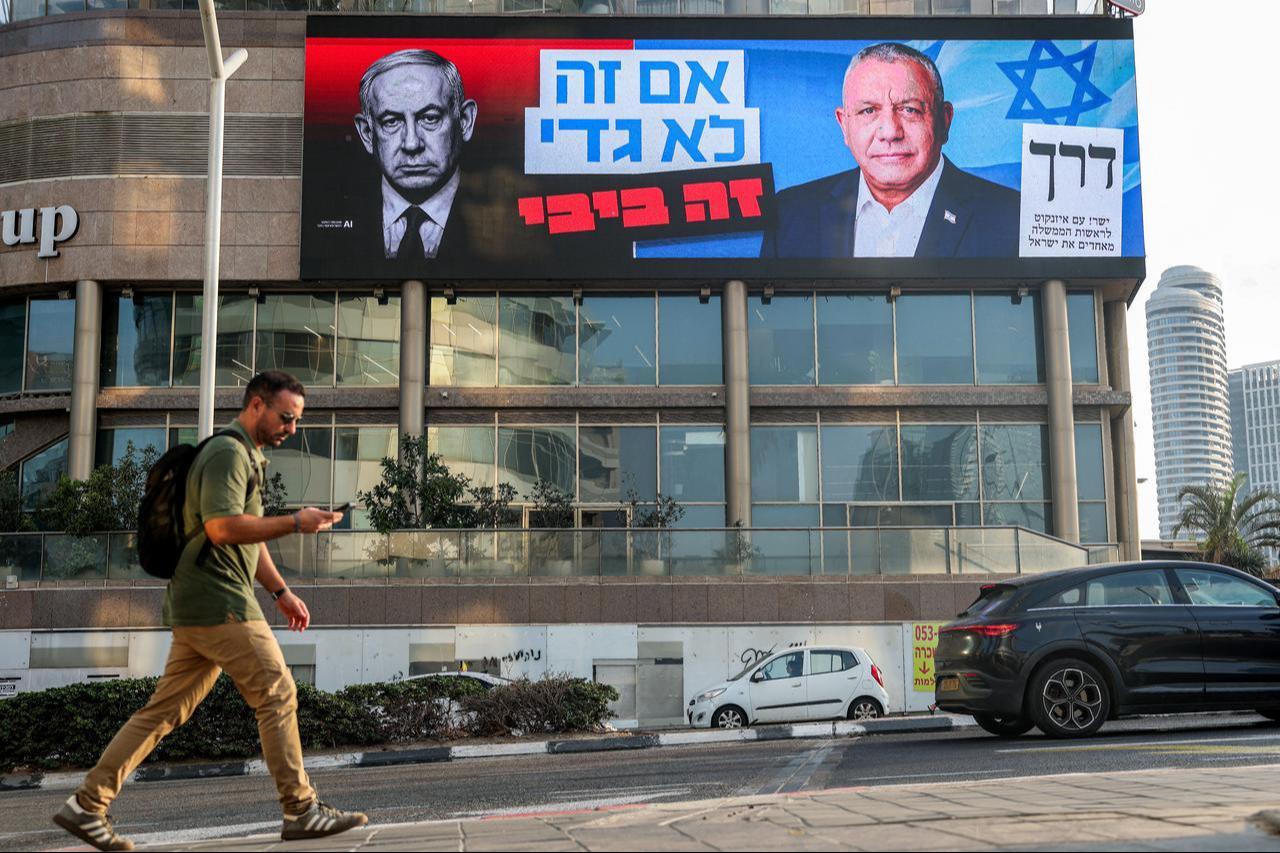 A man walks near an electoral billboard for the Yashar party led by Gadi Eisenkot, Israel's former military chief of staff, in Tel Aviv on October 25, 2026. (AFP Photo)