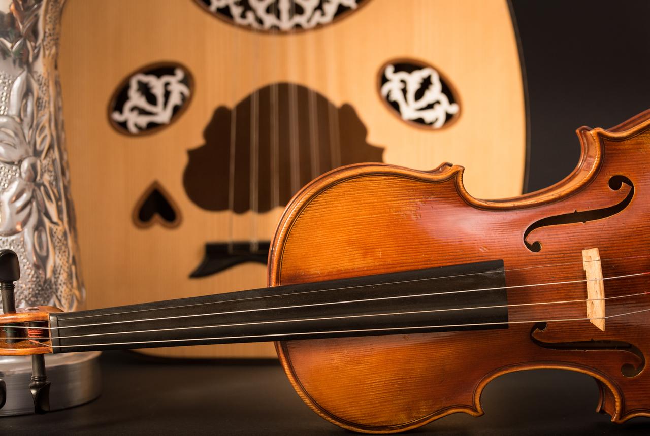 Traditional musical instruments, including a violin and an oud, are displayed together. (Adobe Stock Photo)