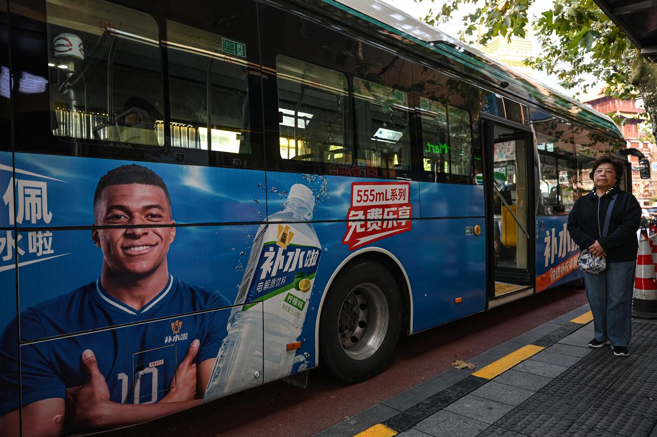 A bus featuring French football star Kylian Mbappe for Dongpeng Beverage Group's "Bushuila" electrolyte drink is seen on a street in Shanghai on Oct. 27, 2026. (AFP Photo)
