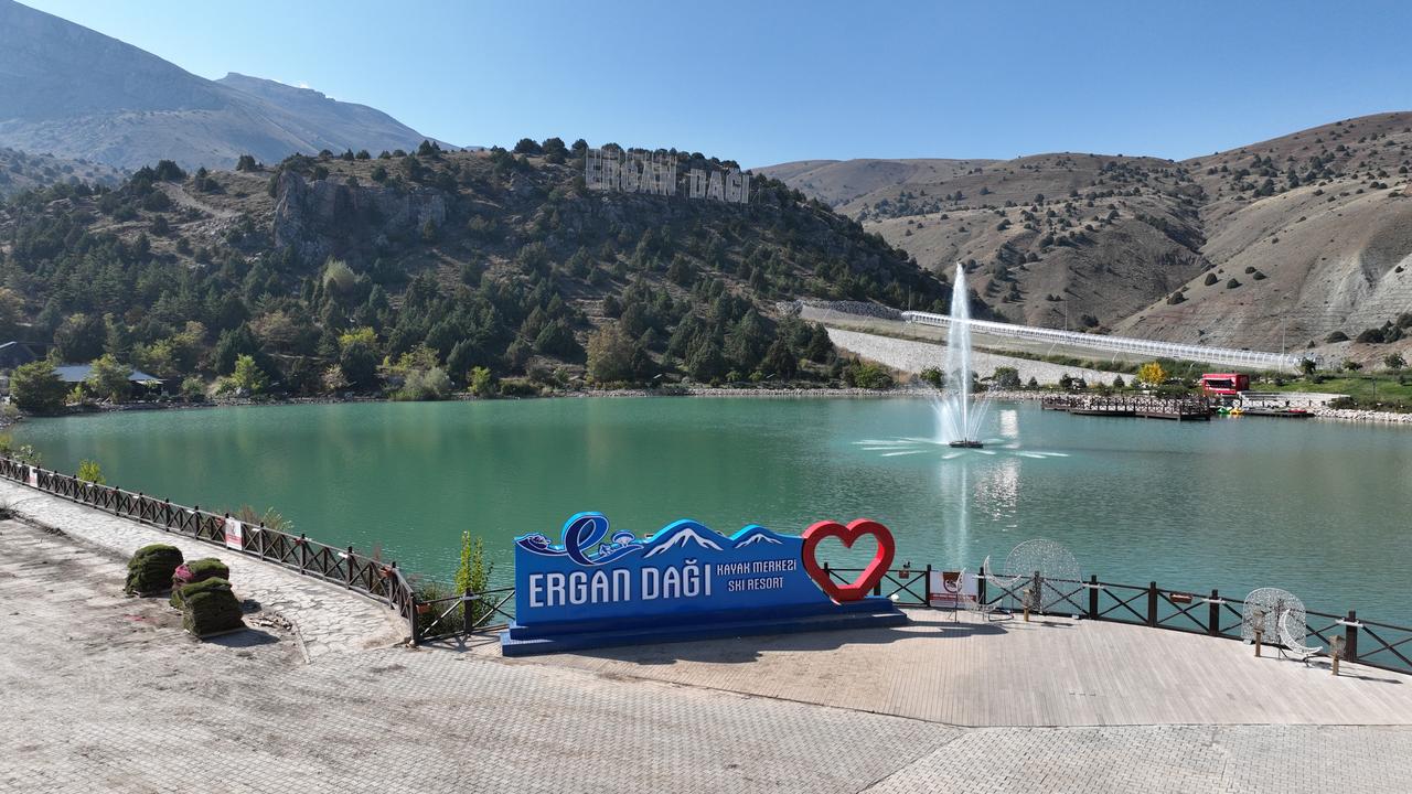 The Ergan Mountain Ski Resort sign stands by artificial lake at the foot of the Munzur Mountains in Erzincan. (AA Photo)