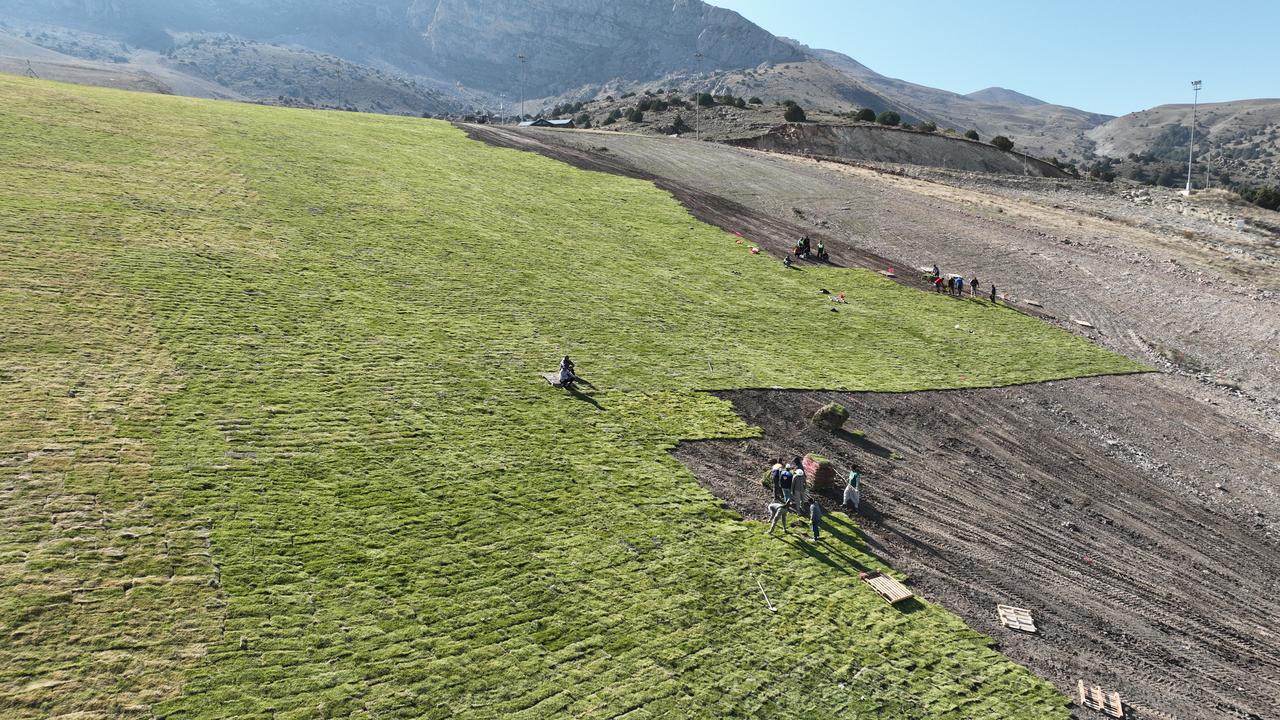 Workers lay grass sod on the ski runs of Ergan Mountain to create a natural cushion that extends snow retention during the winter season. (AA Photo)