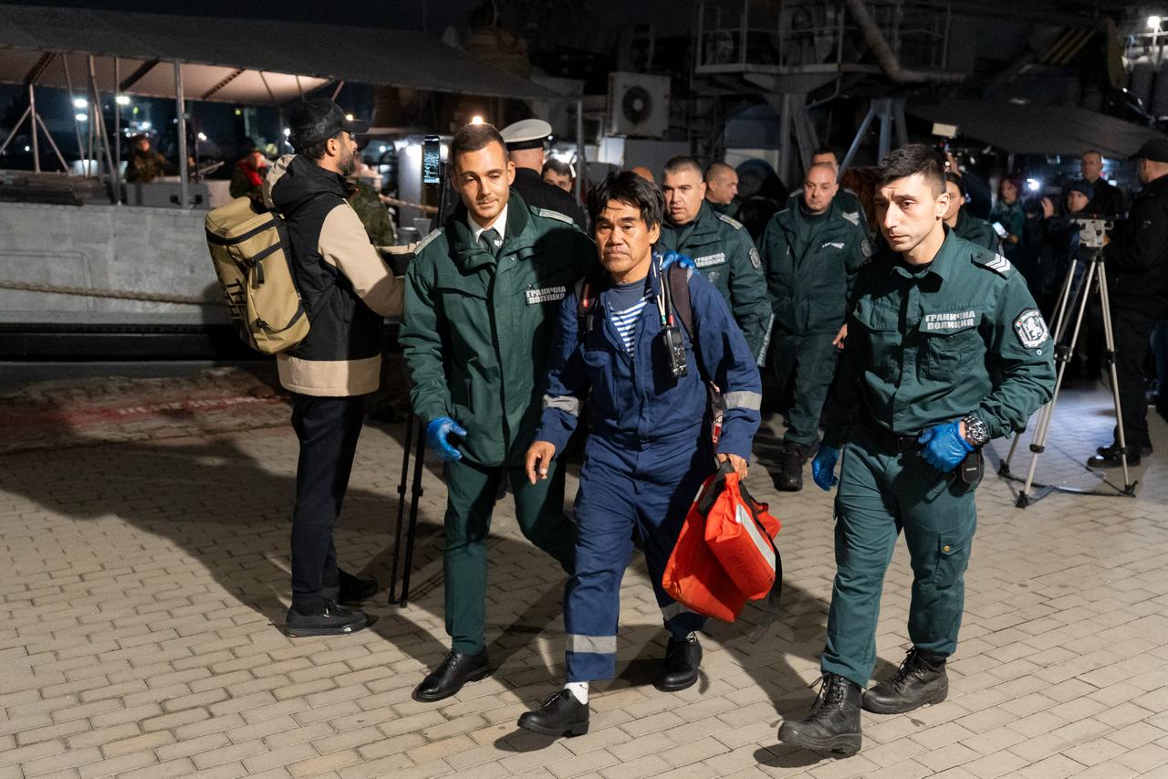 A sailor from a ship hit in a drone attack in the Black Sea off the coast of Bulgaria is escorted by Bulgarian border guards upon arriving at the port of Varna on October 28, 2026. (AFP Photo)
