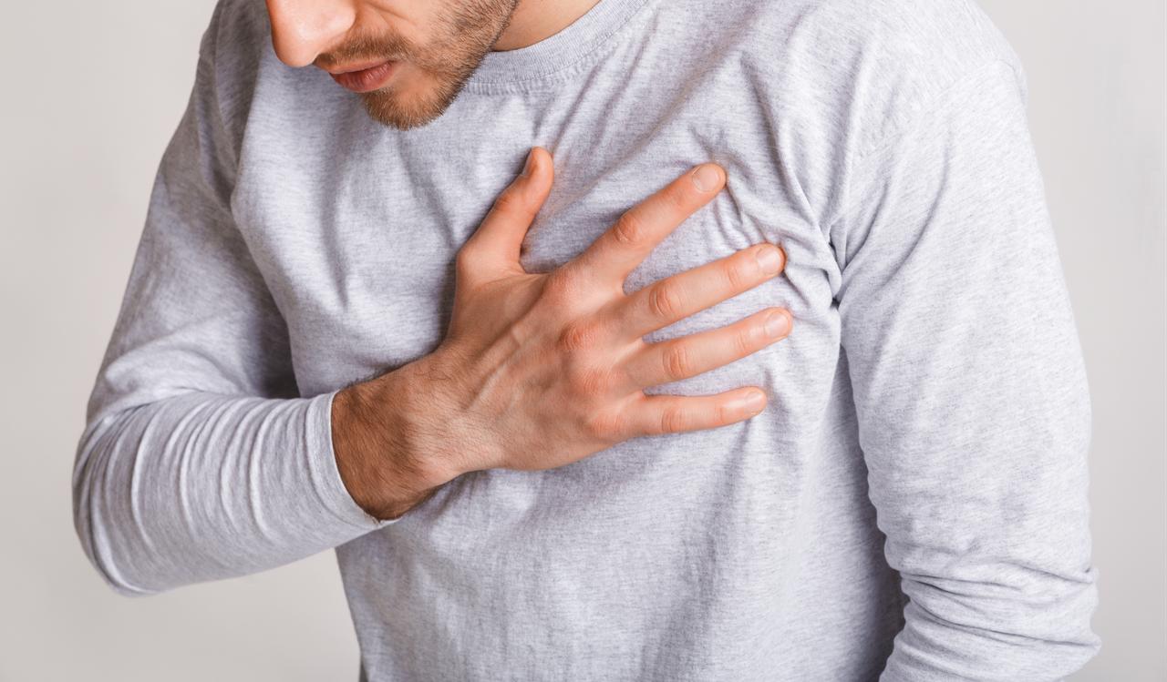A man places his hand on his chest, illustrating chest pain or discomfort. (Adobe Stock Photo)