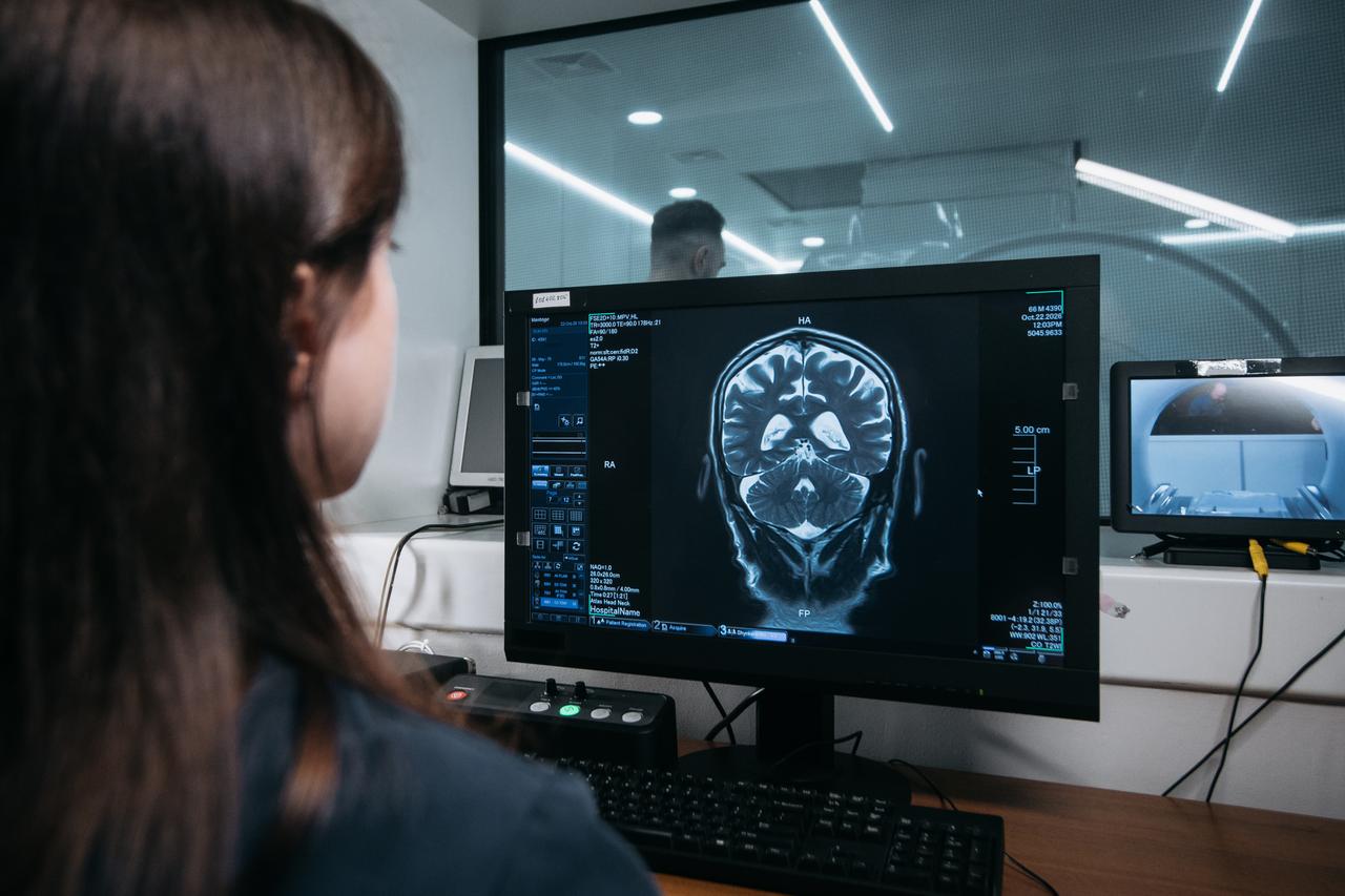 A healthcare professional examines a brain scan displayed on a computer monitor in a medical facility. (Adobe Stock Photo)