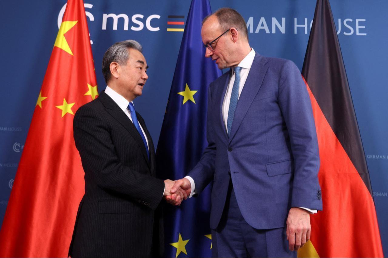 German Chancellor Friedrich Merz (R) and Chinese Foreign Minister Wang Yi shake hands as thez meet for bilateral talks during the 62nd Munich Security Conference (MSC) in Munich, southern Germany, on February 14, 2026. (AFP Photo)