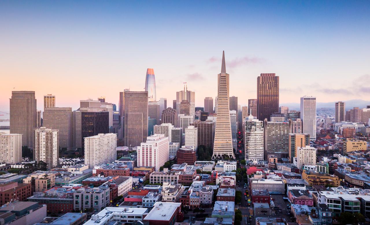 A panoramic view of San Francisco's skyline, including the Transamerica Pyramid and the San Francisco–Oakland Bay Bridge, at sunset in California, U.S. (Adobe Stock Photo)