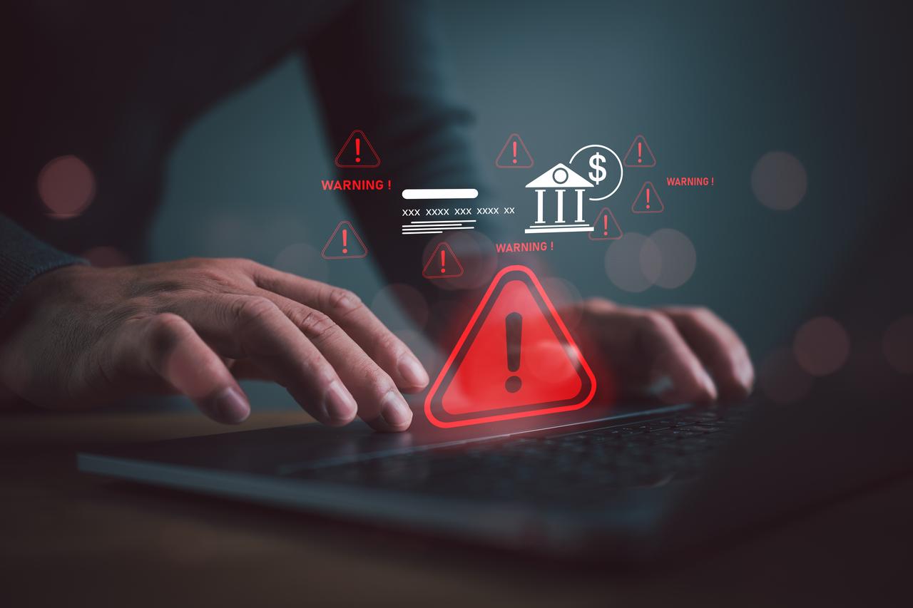 Cybersecurity warning alert for online banking fraud and financial risk detection on a laptop with digital threat notification. (Adobe Stock photo)