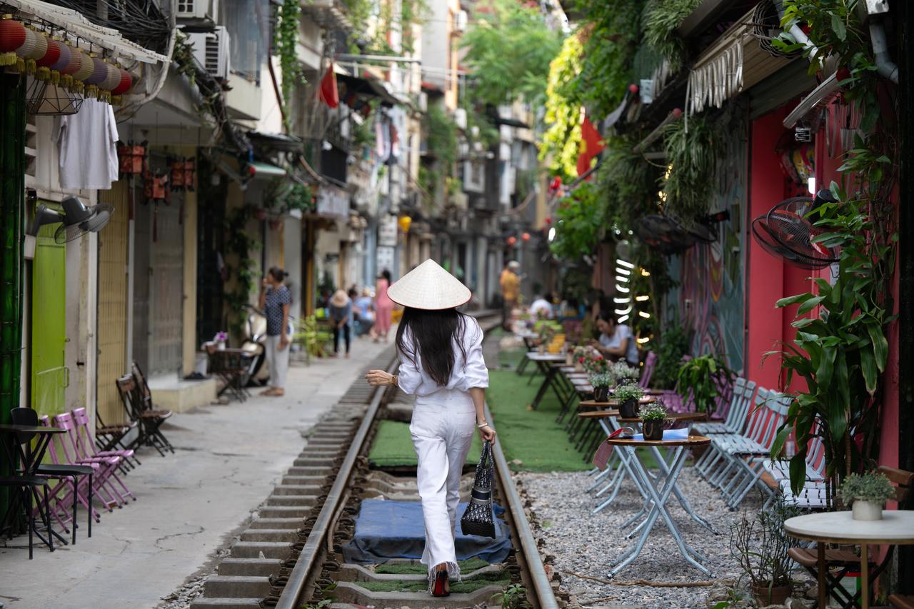 Woman walking in Vietnam's Hanoi Train Street. (Photo via Adobe Stock)