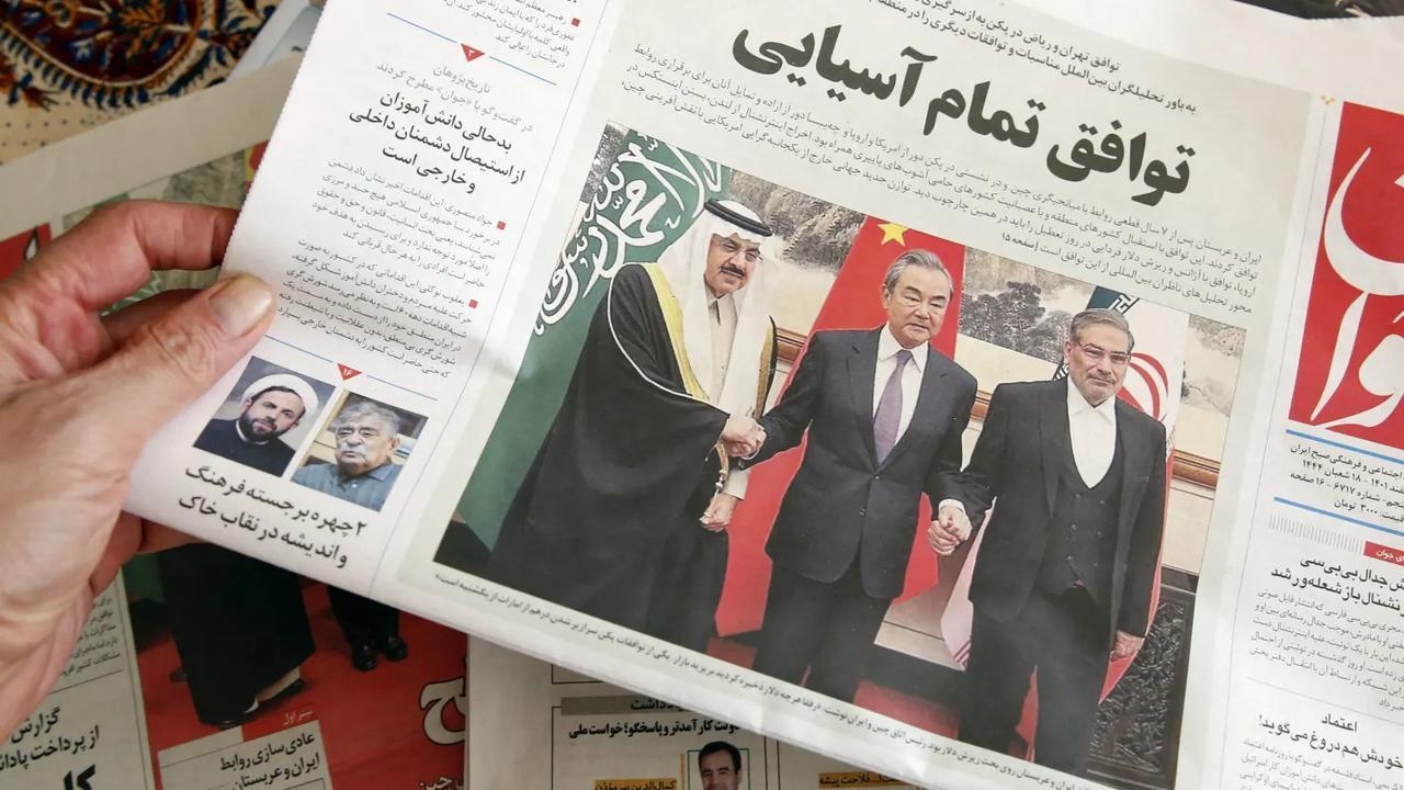 A man in Tehran holds a local newspaper reporting the China-brokered deal between Iran and Saudi Arabia to restore ties on March, 11 2023. (AFP Photo)