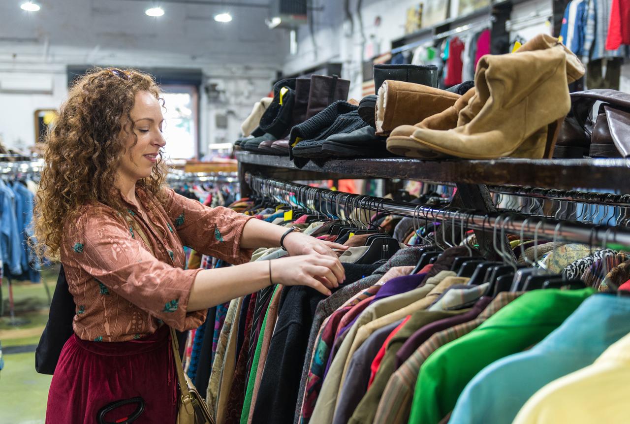 A shopper browses clothing at a secondhand store, illustrating changing consumer habits in fashion. (Adobe Stock Photo)
